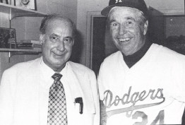 Dr. Robert Woods looks over the hand of Dodgers southpaw Sandy